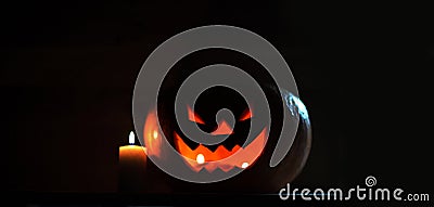 Candle and creepy smiling pumpkin for Halloween Stock Photo