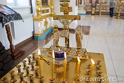 Orenburg, Russian Federation-2 Aprel 2019. the candle and the cross in the Orthodox Church Editorial Stock Photo