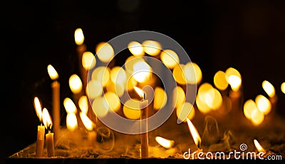 Candle fire yellow illumination flame in christian church darkness space spiritual atmosphere concept background picture divine Stock Photo