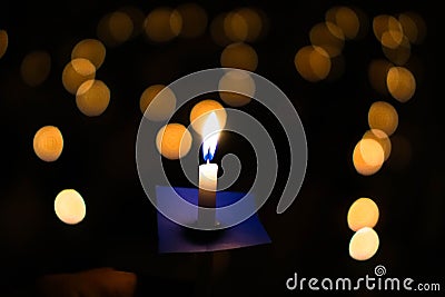 Candle flame at night with bokeh on dark background with go light Blessed is the light of holiness and miracles. Stock Photo