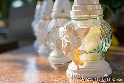 Candle and flowers on grave in cemetery Stock Photo