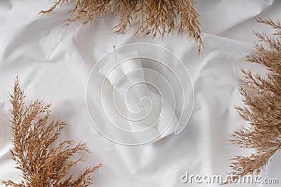 Candle in the form of a female figure on a white fabric background Stock Photo