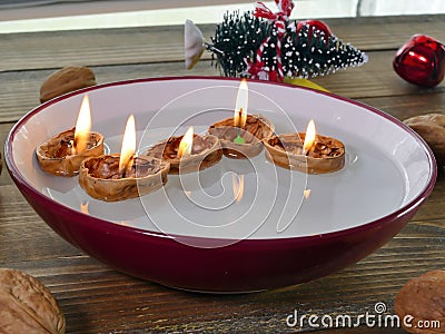 Candle inside walnuts shell floating on water inside bowl Stock Photo