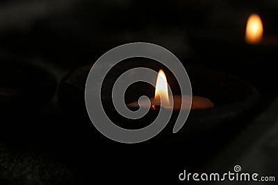 Candle lights on a traditional ceramic bowls on dark background. Holy week concept. Spiritual concepts. Stock Photo