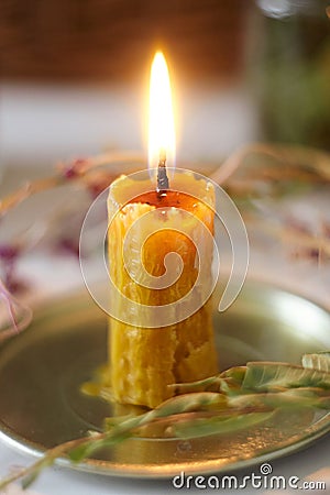 Candle made of real wax handmade, around which are herbs Stock Photo