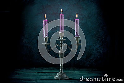 Candle magic. Purple candles in a vintage candle holder Stock Photo