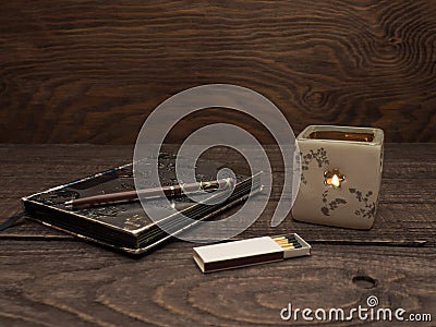 Candle, matches and notebook on a wooden table Stock Photo
