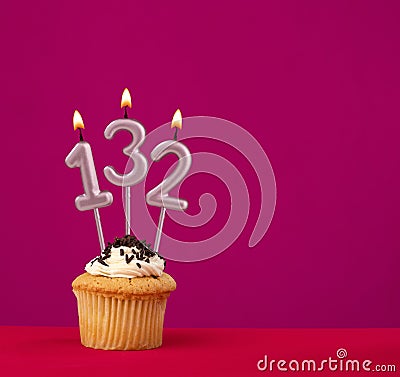 Birthday cupcake with candle number 132 - Rhodamine Red foamy background Stock Photo