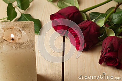 Candle and red roses on a wooden surface - Valentines day concept Stock Photo