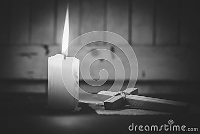 Candle and wooden cross. Concept of Christianity, religiosity and sincere faith Stock Photo