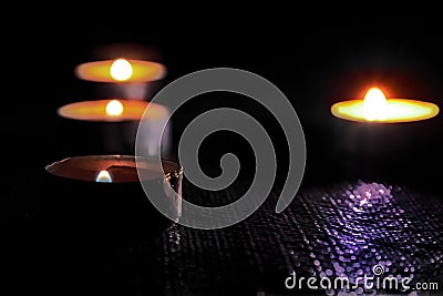 Candles burning on a black background. The concept of grief, mourning. Stock Photo