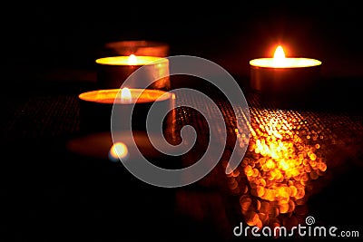 Candles burning on a black background. The concept of grief, mourning. You can use it as a banner. Stock Photo