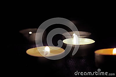 Candles burning in the dark with a soft selective focus. The concept of mourn, grief or mourning. Stock Photo