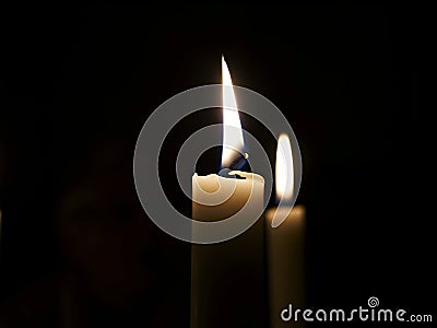 Candles burning in darkness Stock Photo