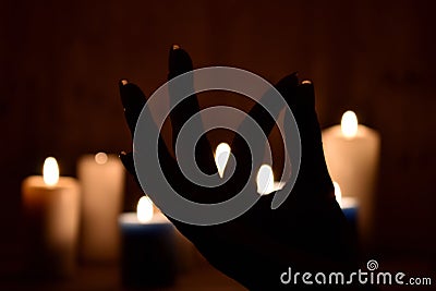 Candles and fingers mudra. Symbol of meditation folded fingers. The figure of the fingers of the mantra Stock Photo