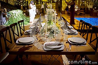 Candles and flowers decoration at night, indoor luxury wedding with low light romantic ambient Stock Photo