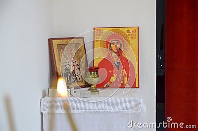 Candles in front of icons in the Orthodox church. A burning wax candles, cross and icons in monastery. Christian religion. Altar i Editorial Stock Photo