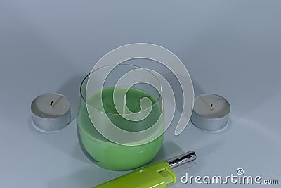 Candles and a green lighter on white isolated background Stock Photo