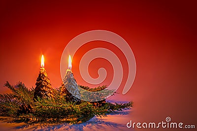 Candles in the shape of Christmas trees on a red background. Stock Photo