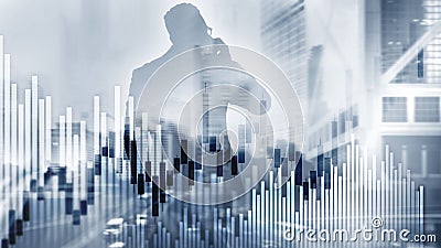 Candles and stock market charts on abstract background. Silhouettes and modern city. Stock Photo