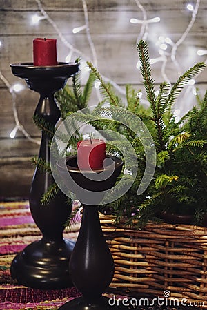 candlestick red candle basket green branch spruce red textile wood wall garland lights illuminated decoration celebration winter Stock Photo