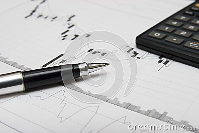 Candlesticks chart, pen and calculator Stock Photo