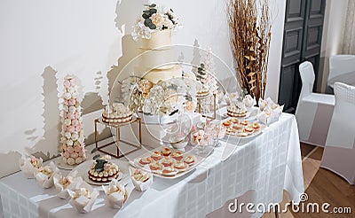 Candy bar at the banquet. Wedding table with sweets, cake, pastries, muffins, sugar treats. Event in the restaurant Stock Photo