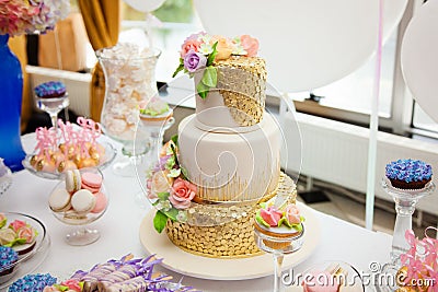 Candy bar on golden wedding party with a lot of different candies, cupcakes, souffle and cakes. Decorated in brown and purple colo Stock Photo