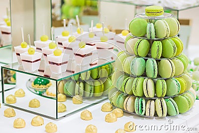 Candy bar with macarons, cakes, cheesecakes, cake pops. Colorful green macaroons pyramide Stock Photo