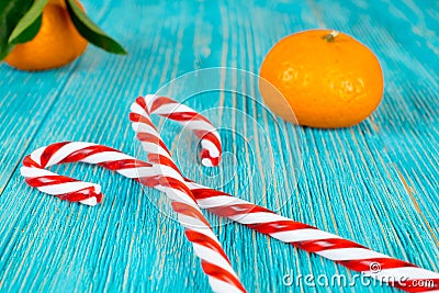 Candy canes heart and tangerines on wooden planks, xmas background Stock Photo