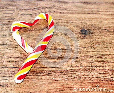 Candy in the shape of heart on a wooden background for the celebration of Valentine`s Day. Heart is broken. Cheating Stock Photo