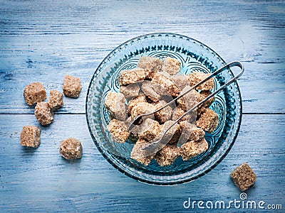 Cane sugar cubes in the old-fashioned glass plate. Stock Photo