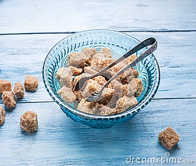 Cane sugar cubes in the old-fashioned glass plate. Stock Photo