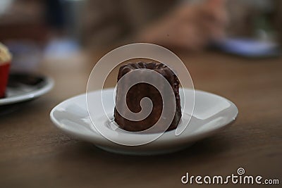 Caneles de bordeaux in white plate on wooden table. Traditional French sweet dessert Stock Photo