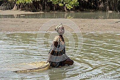 Unidentified local woman pulls a fishing net in the water in a Editorial Stock Photo