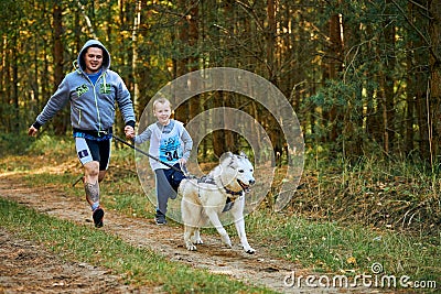 Canicross cross country running with dog, father and son running with Husky dog, family sports Editorial Stock Photo