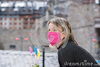 Blonde woman with face mask worried about the Covid-19 outbreak staying at home. Editorial Stock Photo