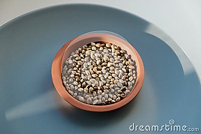 Cannabis seeds close-up. Marijuana seeds with storage jar on blue background Stock Photo