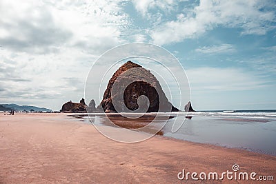 Cannon Beach, Oregon coast: the famous Haystack Rock reflects itself in the water Editorial Stock Photo