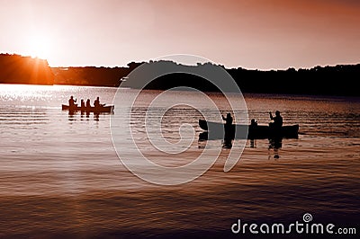 Canoers on the lake with setting sun Stock Photo