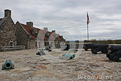 Canons along outer wall and on the stone pavers in front of the barracks in Fort Ticonderoga, Ticonderoga, New Yor Editorial Stock Photo