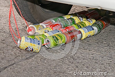 Cans of soda and beer placed on strings behind the wedding car. Editorial Stock Photo