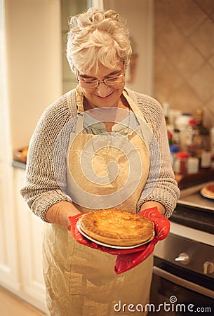 Cant wait to dig in. An elderly lady holding a pie that shes just baked. Stock Photo