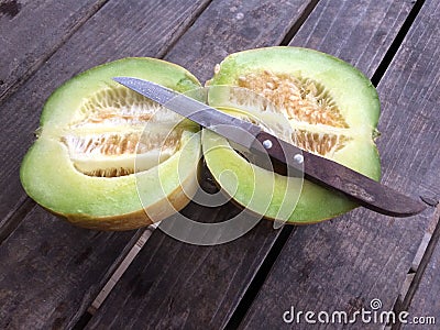 Cantaloupe or muskmelon and knife on old wooden table Stock Photo