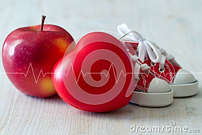 Canvas shoes, apple and red heart with cardiogram line, diet and sport for healthy heart concept Stock Photo