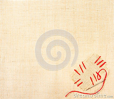 Canvas with stiched patch and needle over burlap Stock Photo