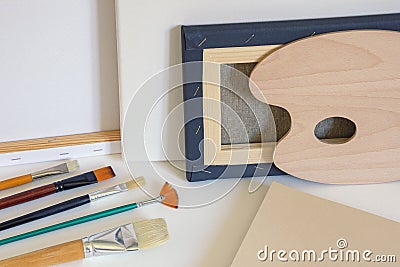 Canvases, paintbrushes, palette and drawing paper. Copy space Stock Photo