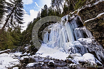 Canyon wall covered in frozen ice formations along a mountain river Stock Photo