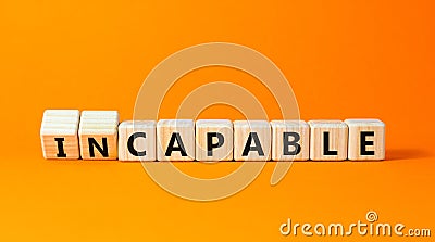 Capable or incapable symbol. Concept words Capable or Incapable on wooden cubes. Beautiful orange table orange background. Stock Photo