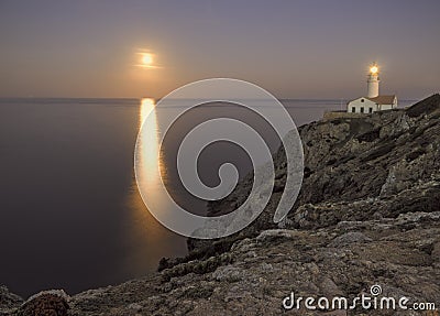 Capdepera lighthouse at dusk, with moonbeam on sea and rocks, mallorca, spain Stock Photo